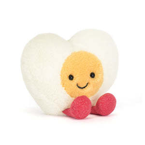 Jellycat white egg shaped plush toy with a yellow smiling face and red sparkly feet on a white background
