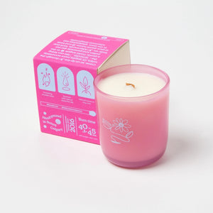 Pink candle beside a pink box with purple branding on a white background.