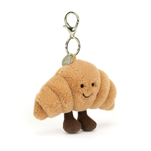 adorably soft bag charm of a smiling croissant with legs by popular brand Jellycat.