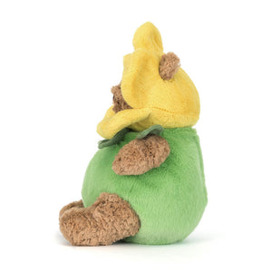 Side view of a brown Jellycat bear plush wearing a green and yellow daffodil outfit on a white background