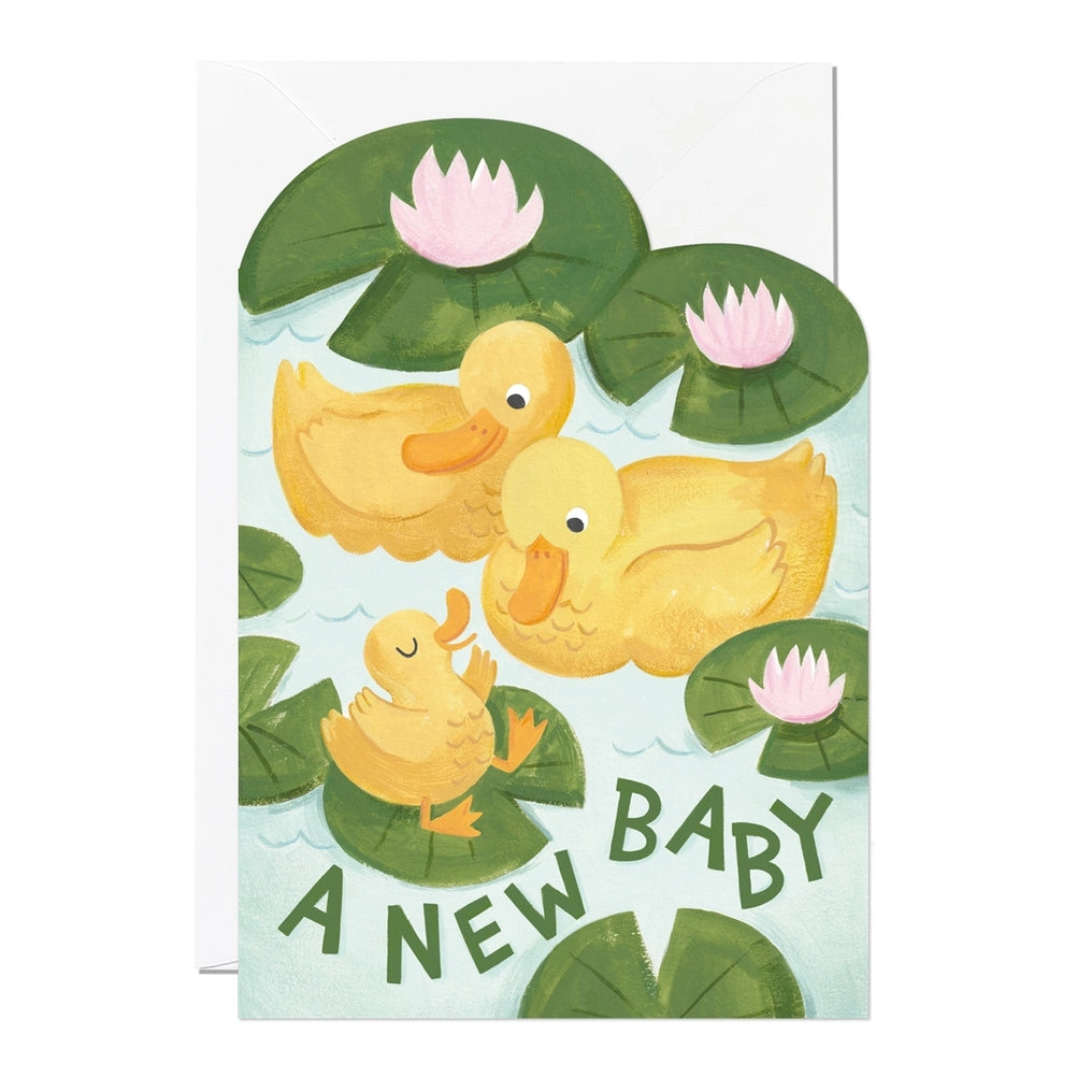 Greeting card featuring two big yellow ducks in a pond with lily pads along with a baby duck sitting on top of a lily pad. The card contains the text 'A New Baby'.