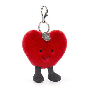 adorably soft bag charm of a red smiling heart with legs by popular brand Jellycat.