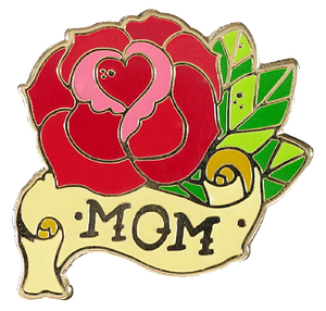 shape-cut enamel pin of a red rose with a heart at its core, leaves, and a parchement banner. the text on the banner reads "mom"