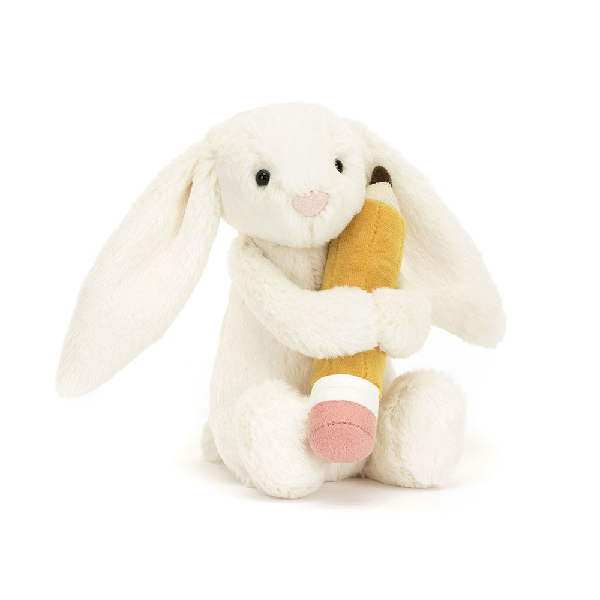adorably soft plushie of a sitting white bunny holding a pencil by popular brand Jellycat.