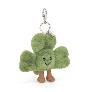 Front view of a Jellycat plush bag charm shaped like a green clover with a smiling face on a white background