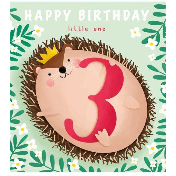 cute birthday card with a cartoonish hedgehog wearing a crown. its stomach is exposed, revealing that  the animal is holding a red number three. "happy birthday little one" is written above in white and red